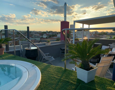 Terrazza con jacuzzi, piante e vista al tramonto.