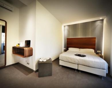 Modern room with double bed and wall mirror.