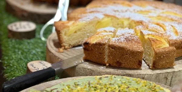 Dolci vari su tavoli di legno, inclusa torta al pistacchio.