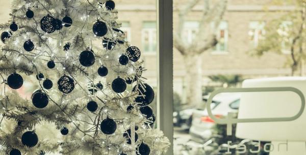 Albero di Natale bianco con decorazioni nere in una stanza luminosa.