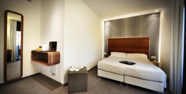 Modern room with double bed and wall mirror.